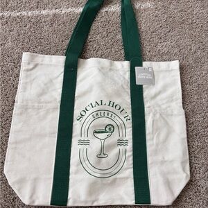 totes Cream Canvas Tote Bag with Green Straps and Social Hour Print